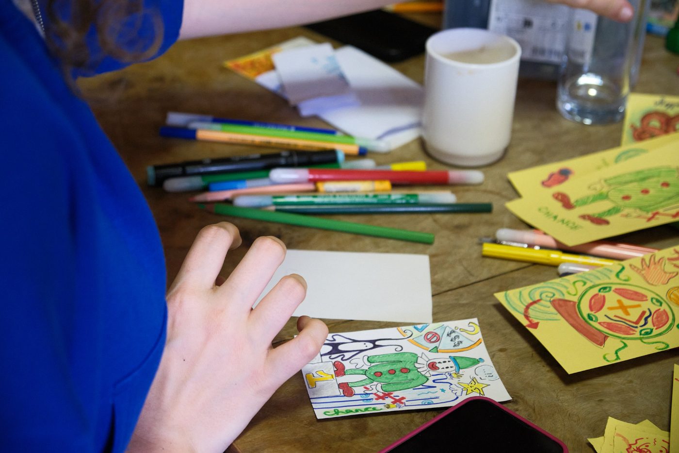 A participant finishing a colourful card with the word chance