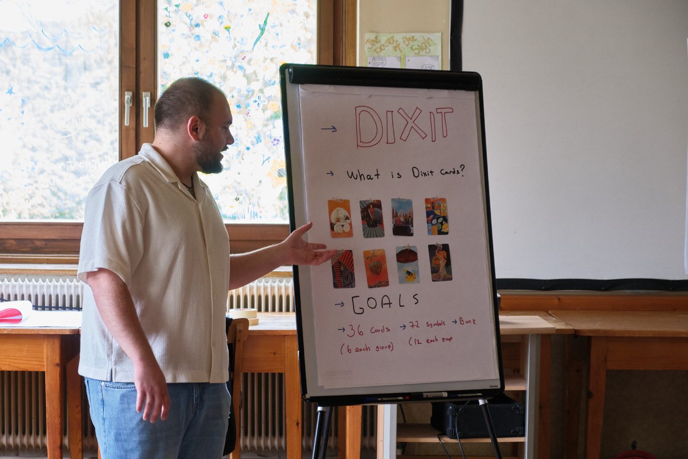 A facilitator introducing the Dixit card activity at the flipchart
