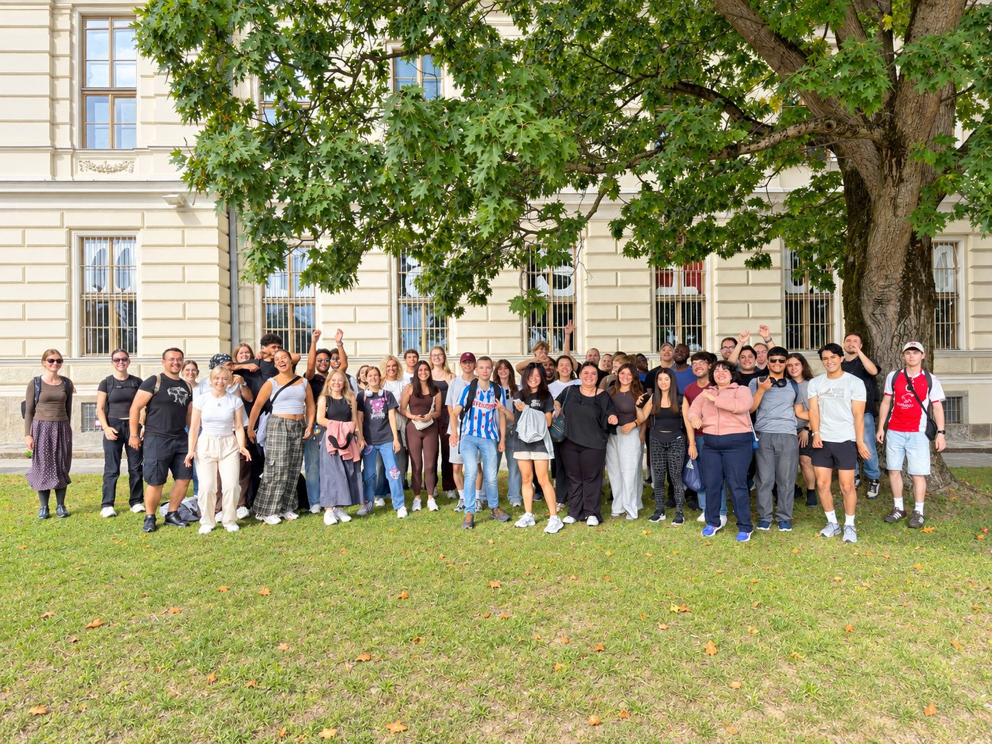 Exchange students and SNJKU buddies in a group photo on the lawn under a large tree